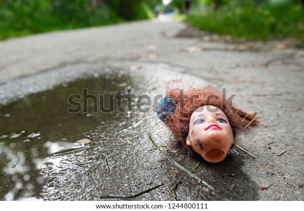 freaky, weird doll head on\
the pathway