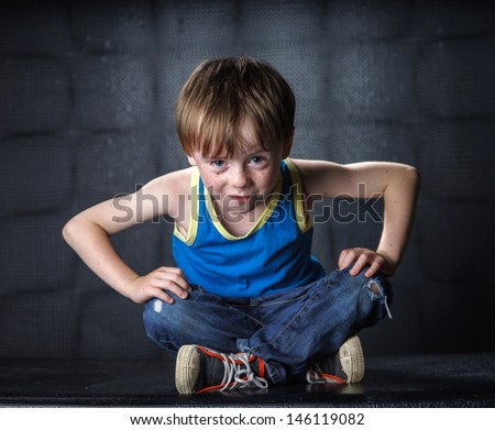 Freckled red-hair boy posing on dark background. Emotions.