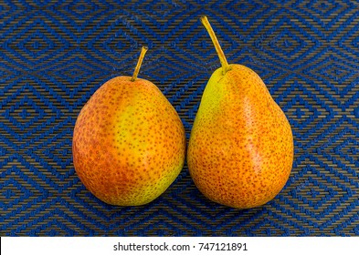 freckled two pear fruit orange yellow on a blue background, delicious fresh snack