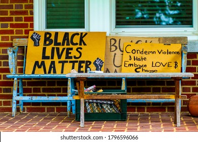 Frederick, MD, USA 08/14/2020: Card Board Signs Condemning Racial Discrimination Against African Americans Are Placed On An Old  Wooden Bench On The Porch Of A House In Frederick, MD