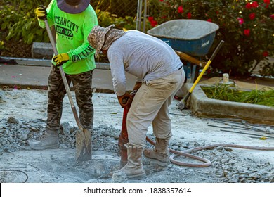 Frederick, MD, USA 10/13/2020: Two Construction Workers Are Drilling The Concrete Floor Of A Section Of Baker Park With A Hex Breaker Hammer. One Shovels The Rubble As The Other One Drills. 