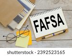 Free Application for Federal Student Aid (FAFSA) concept. text on a notepad with a clip. glasses on stickers