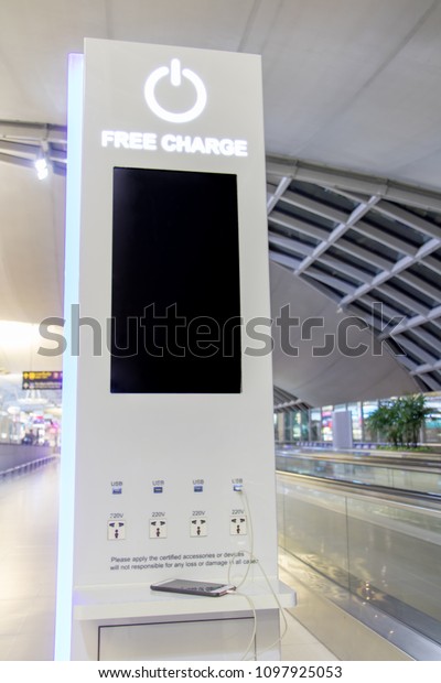 Free battery charging station in\
the airport for traveler. Phone charging on a table at charging\
station in the lobby. Free charging on the airport\
terminal.