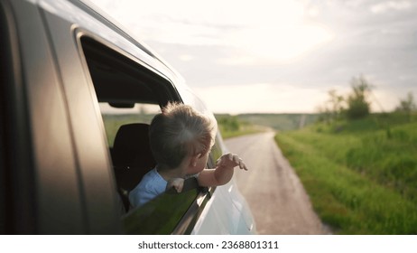 free boy kid hand from the window rides in a car wind in the face. conceptual journey of car on the road. The boy son stretches out his hand from the car window, the sun glare of sunset lifestyle - Powered by Shutterstock