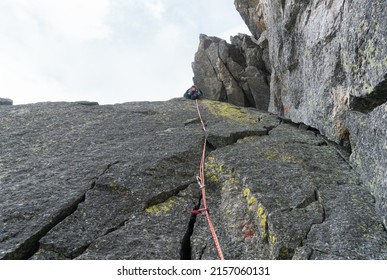 Free climber on dangerous trad rock climbing route Mellano-Perego on Becco di Valsoera, a mountain in Piantonetto valley in the Alps of Piedmont