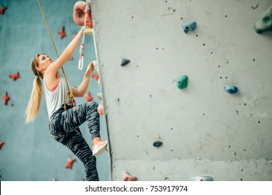 Free climber young woman climbing artificial boulder indoors - Powered by Shutterstock