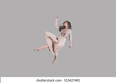 Free Falling. Studio Shot Of Attractive Young Woman Hovering In Air