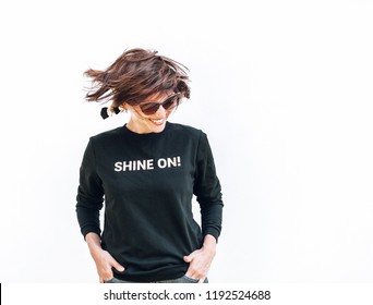 Free feeling happy smiling woman posing in black sweatshirt with positive print Shine On
