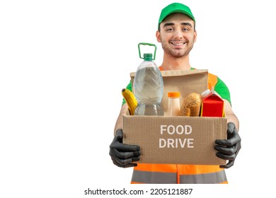 Free Food Distribution, Food Drive. Volunteer Carrying Food Donation Box. Young Smiling Man Wearing Orange Vest Holds Out Grocery Set For In-need People. White Isolated Background.