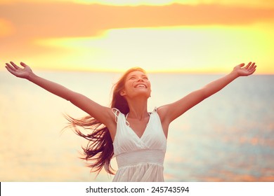 Free Happy Woman Arms Up Praising Freedom At Beach Sunset. Young Adult Enjoying Breathing Freely Fresh Air.