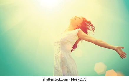 Free Happy Woman Enjoying Nature. Beauty Girl Outdoor. Freedom concept. Beauty Girl over Sky and Sun. Sunbeams. Enjoyment.  