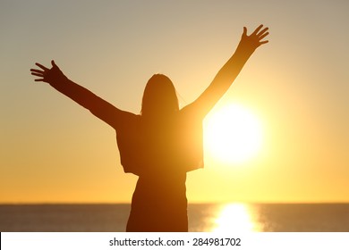 Free Happy Woman Raising Arms Watching The Sun In The Background At Sunrise