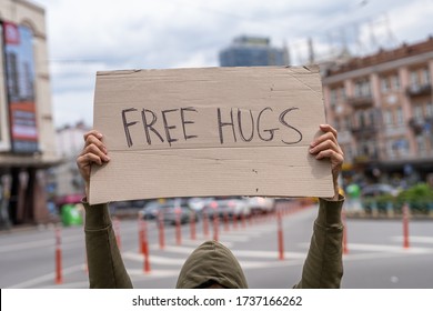 Free hugs. Love, kind, happy and friends positive support. Having fun outside relationship on street.  Social public messages on banners outside on streets.  reflection phrases self respect.  - Shutterstock ID 1737166262