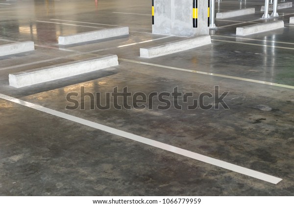 Free parking stalls in a parking lot, marked\
with white lines. Empty parking\
lot.