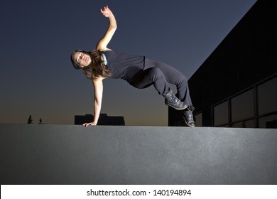 free runner doing parkour at night on a rooftop - Powered by Shutterstock