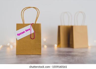 free samples and gifting conceptual still-life, shopping bag with price tag with Goodie Bag text on it and other bags in the background shot at shallow depth of field with bokeh and fairy lights - Shutterstock ID 1559160161