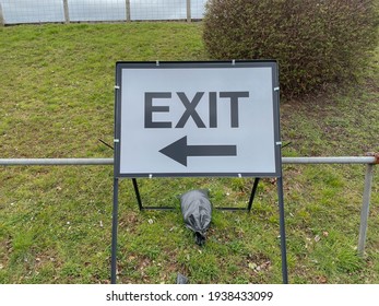 Free Standing Metal Exit Sign Weighed Down By  Sandbags By A Grass Bank With Directions For Vehicles Leaving An Outdoor Car Park In The City Of Exeter, England, UK