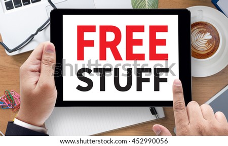 FREE STUFF, on the tablet pc screen held by businessman hands - online, top view