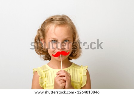 Free time for fun. Close up portrait of fancy, funky small girl with fake red paper mustache isolated on grey background with copy space for text. 