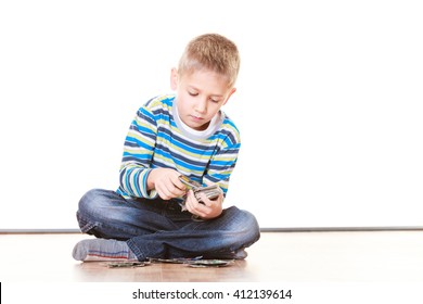 Free time, fun and hobby. Little boy play indoors sit on floor and play collect cards. - Powered by Shutterstock