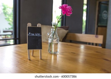 Free Wifi Board On Wooden Top Table With Blurred Of Coffee Shop