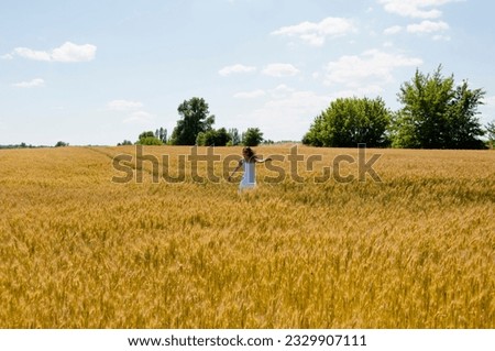 Similar – Woman alone in a field of wheat