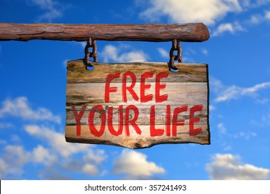 Free your life motivational phrase sign on old wood with blurred background