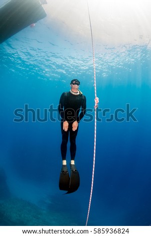 Similar – From below full body of unrecognizable active teen boy wearing yellow flippers snorkeling by coral reef in deep ocean with crystal clear waters at Menorca