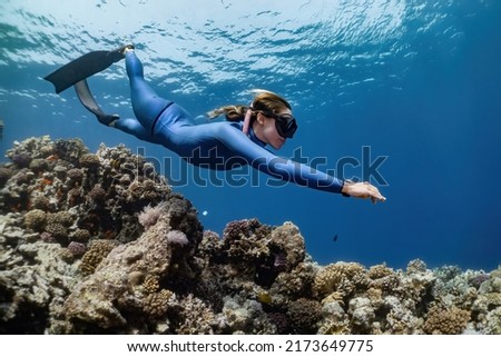 freediver girl on coral reef, in the sea. underwater