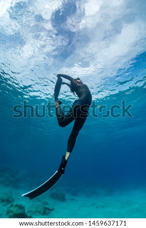 Similar – From below full body of unrecognizable active teen boy wearing yellow flippers snorkeling by coral reef in deep ocean with crystal clear waters at Menorca