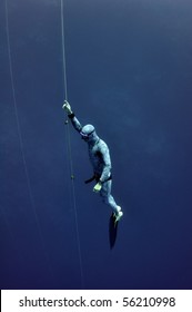 Freediver slowly raises from the depth using safety rope
