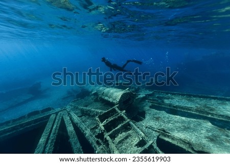 Freediver Swimming in Deep Sea and Exploring Ship Wreck. Young Man Diver Eploring Sea Life.