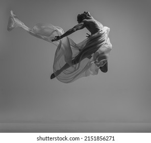 Freedom. Black and white portrait of graceful muscled male ballet dancer dancing with fabric, cloth isolated on grey background. Grace, art, beauty, contemp dance concept. Weightless, flexible actor - Powered by Shutterstock