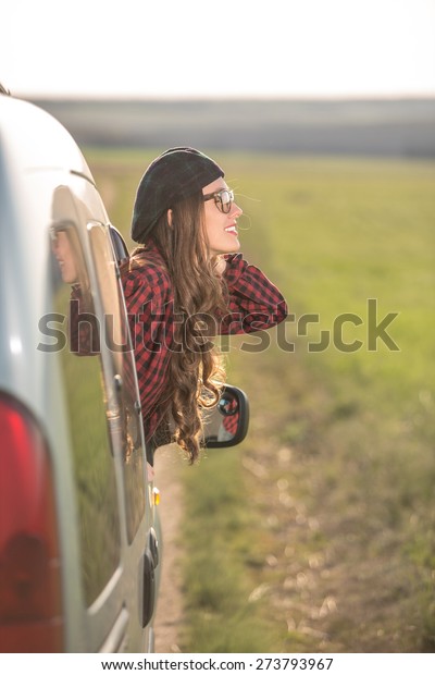  Freedom\
car travel concept - woman relaxing out of window in a car. Girl\
relaxing enjoying free holidays road\
trip