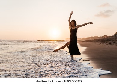 Freedom Chinese woman feeling free dancing in black elegant dress at beach sunset. Healthy living Asian girl on summer travel vacation. Success, happiness, mindfulness concept. - Powered by Shutterstock