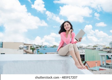 Freedom Concept. Enjoyment. Asian Young Woman Relaxing Under Blue Sky On Rooftop