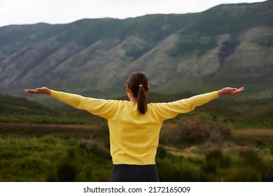 Freedom Concept. Solitude. Peace Of Mind. Relax. Back View Of Woman Standing Against Mountains Landscape With Arms Up 