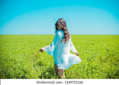 Freedom concept. Young happy woman in green field, evening light. Blue sky behind.
Beauty Girl Outdoors enjoying nature. Beautiful Teenage Model girl in white dress running on the meadow