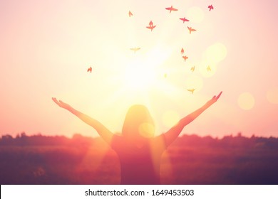 Freedom and feel good concept. Copy space of silhouette woman rising hands on sunset sky double exposure colorful bokeh light and birds fly background. Vintage tone filter effect color style. - Powered by Shutterstock