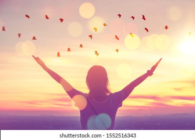 Liberdade, sinta-se bem e conceito de aventura de viagem. Copie o espaço da mulher silhueta levantando as mãos no céu por do sol no topo da montanha e do pássaro voar fundo abstrato. Estilo de cor de efeito de filtro de tom vintage.