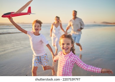 Freedom, happy family and beach with happy children running and playing with parents. Travel, wellness and energy with excited kids bonding and having fun, laugh on fun activity with mom and dad - Powered by Shutterstock