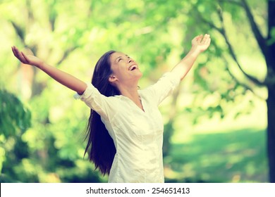 Freedom Happy Woman Feeling Alive And Free In Nature Breathing Clean And Fresh Air. Carefree Young Adult Dancing In Forest Or Park Showing Happiness With Arms Raised Up. Spring Allergies Concept.