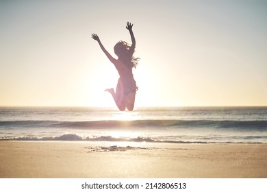 Freedom lies in being bold. Shot of a young woman jumping into mid air at the beach. - Shutterstock ID 2142806513