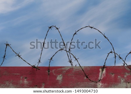Freedom motivational inspiring quote and landscape with barbed wire fence background. Concept of refugees, immigration and restrictions