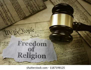 Freedom of Religion newspaper headline on a copy of the US Constitution with gavel                              