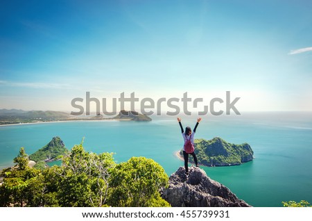 Freedom traveler woman standing with raised arms on the top of mountain at Khao Lom Muak and enjoy the beautiful of seascape, travel, freedom, Thailand.