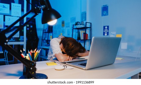 Freelance Asia exhausted lady hard work sleeping at new normal home office. Working from house overload at night, Remotely, self isolation, social distancing, quarantine for corona virus prevention. - Shutterstock ID 1991136899