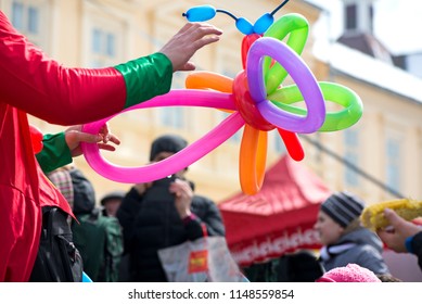A freelance clown creating balloon animals and different shapes at outdoor festival in city center. School bag, angel wings, butterflies and dogs made of balloons. Concept of entertainment, birthdays - Powered by Shutterstock