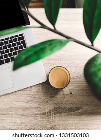 Freelance Concept. Top View Of Coffee In Glass Cup And Laptop On Stylish Wooden Table With Green Plant. Working Home. Phone Photo