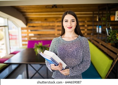Freelance developer or designer with notebooks and papers standing at office